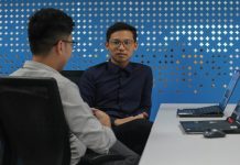 two men sitting at a table talking to each other