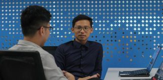 two men sitting at a table talking to each other
