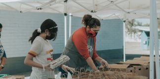 man in red t-shirt holding white plastic bottle
