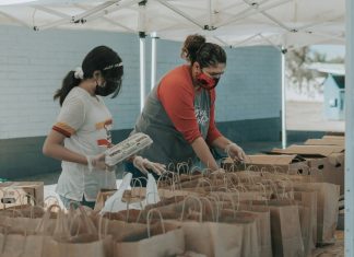 man in red t-shirt holding white plastic bottle