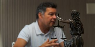 A man sitting at a table in front of a statue