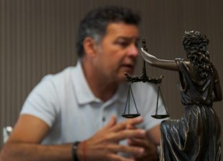 A man sitting at a table in front of a statue