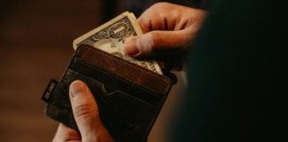 person getting 1 U.S. dollar banknote in wallet