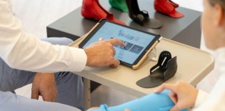 a person sitting at a table with a tablet