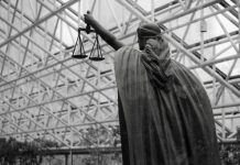 Statue of lady justice holding scales indoors