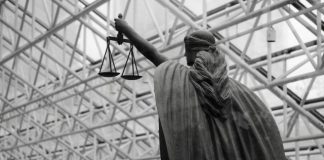 Statue of lady justice holding scales indoors