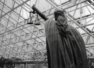 Statue of lady justice holding scales indoors
