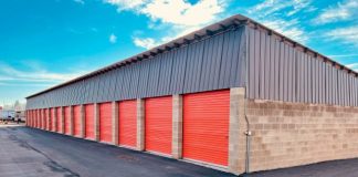 a storage building with red doors and a sky background