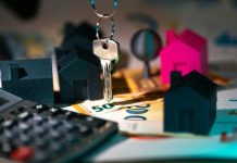 A calculator, keychain, and house model on a table