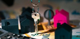 A calculator, keychain, and house model on a table