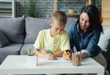 Mother and son drawing together at a table.