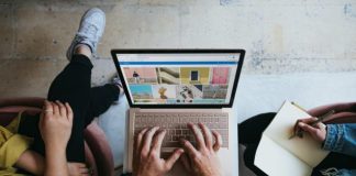 person using microsoft surface laptop on lap with two other people