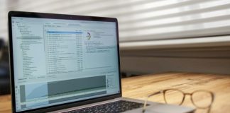 Laptop and glasses on a wooden desk.