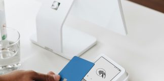 A person holding a card in front of a computer