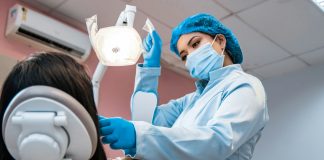 a woman getting her teeth brushed by a dentist