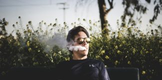 man sitting on bench and smoking