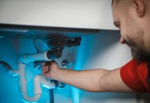 a man working on a pipe in a wall