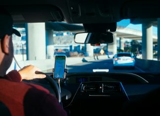 The Digital Safety Gap: Navigating Corporate Liability and Passenger Rights in the Rideshare Era person holding iphone 6 inside car