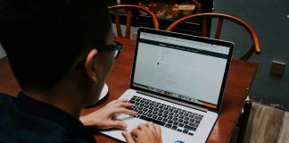 a man sitting at a table using a laptop computer