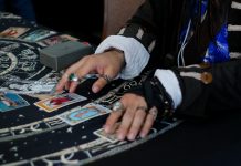 Hands arranging tarot cards on a celestial patterned cloth.