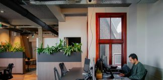 a man sitting at a desk working on a laptop