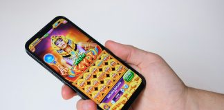 A hand holds a phone with an egyptian-themed game.
