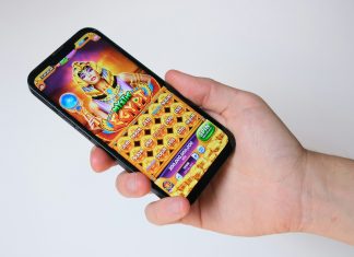 A hand holds a phone with an egyptian-themed game.