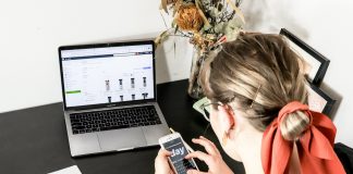 woman in orange shirt using iphone