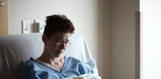 woman on bed holding plastic cup