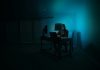 a person sitting at a desk in a dark room