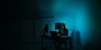 a person sitting at a desk in a dark room