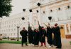 people in black academic dress standing on green grass field during daytime