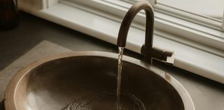 Water flowing into a bronze sink basin.