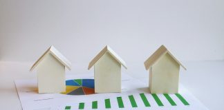 three small houses sitting on top of a piece of paper