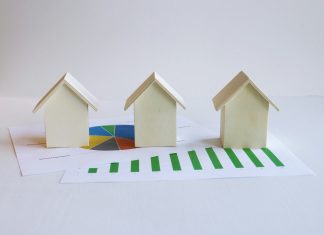 three small houses sitting on top of a piece of paper