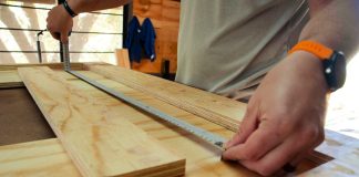 person in white shirt holding brown wooden table