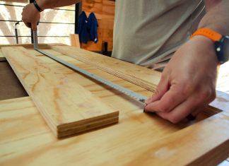 person in white shirt holding brown wooden table