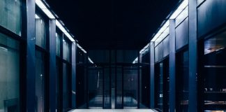 a long hallway with glass doors leading to another room