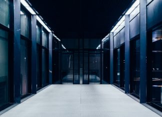 a long hallway with glass doors leading to another room