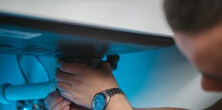 a man fixing a water heater in a room