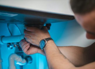 a man fixing a water heater in a room
