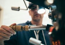 man wearing black pullover hoodie holding tool