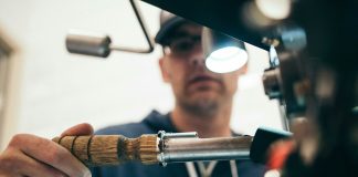 man wearing black pullover hoodie holding tool