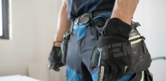 a man wearing a pair of black and blue work gloves