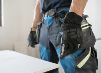 a man wearing a pair of black and blue work gloves