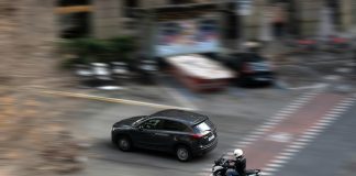 a car and a motorcycle driving down a street