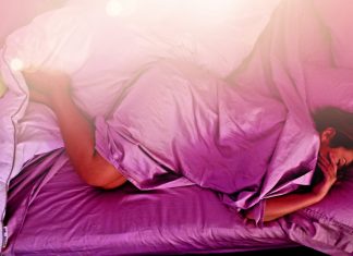 person lying on purple bed