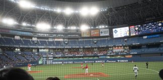 Baseball game in a stadium with spectators watching.