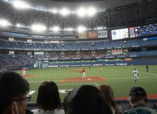 Baseball game in a stadium with spectators watching.