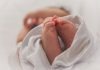 baby covered with white blanket